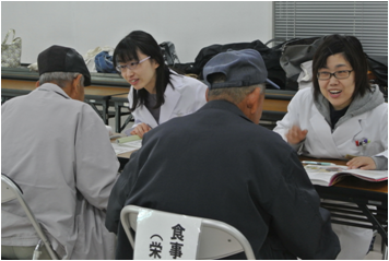 健康相談の会場内で、薬剤師・栄養士が来場者に健康相談を行っている様子