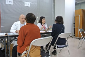 健康相談の会場内で、薬剤師・栄養士が来場者に健康相談を行っている様子